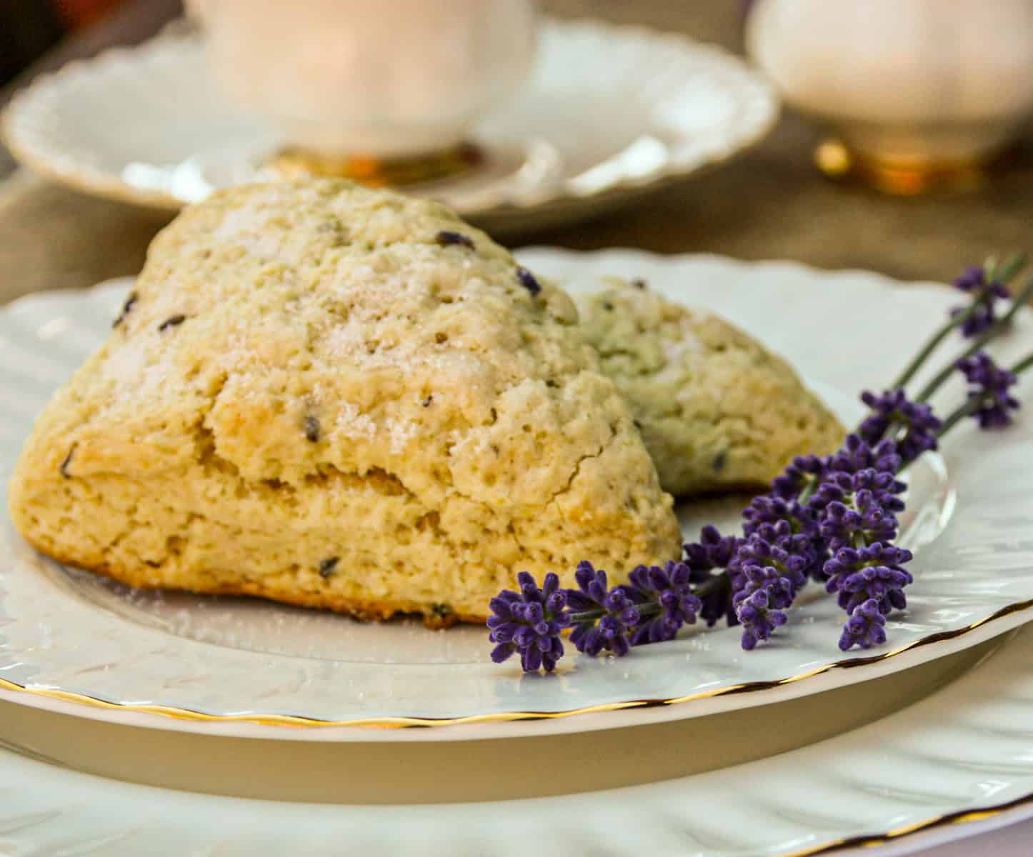 Two lavender scones on a China plate with lavender sprigs.