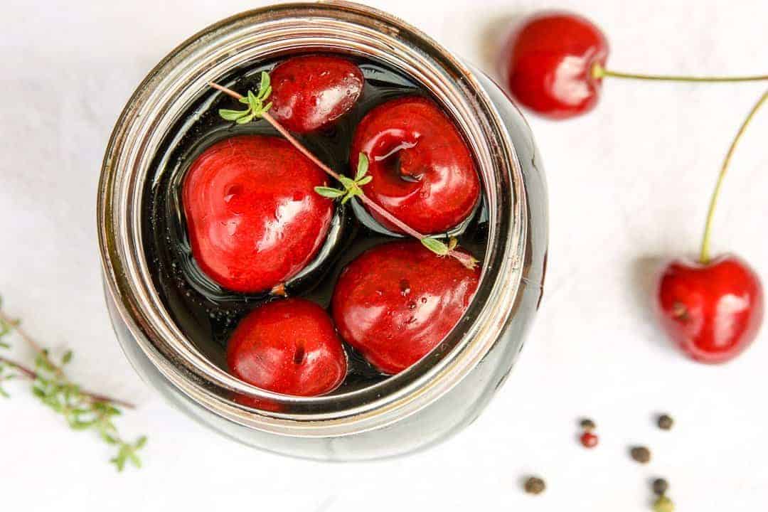 A close up of a jar of cherries