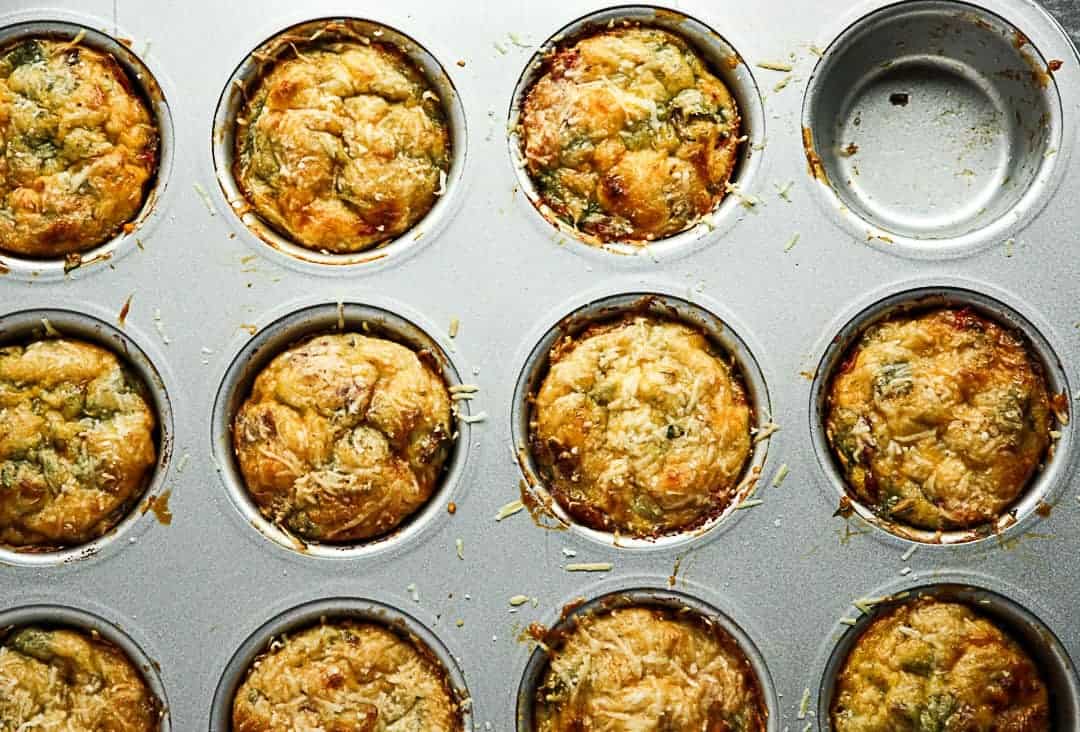 A muffin pan with Baked Bacon & Spinach Breakfast Egg Cups