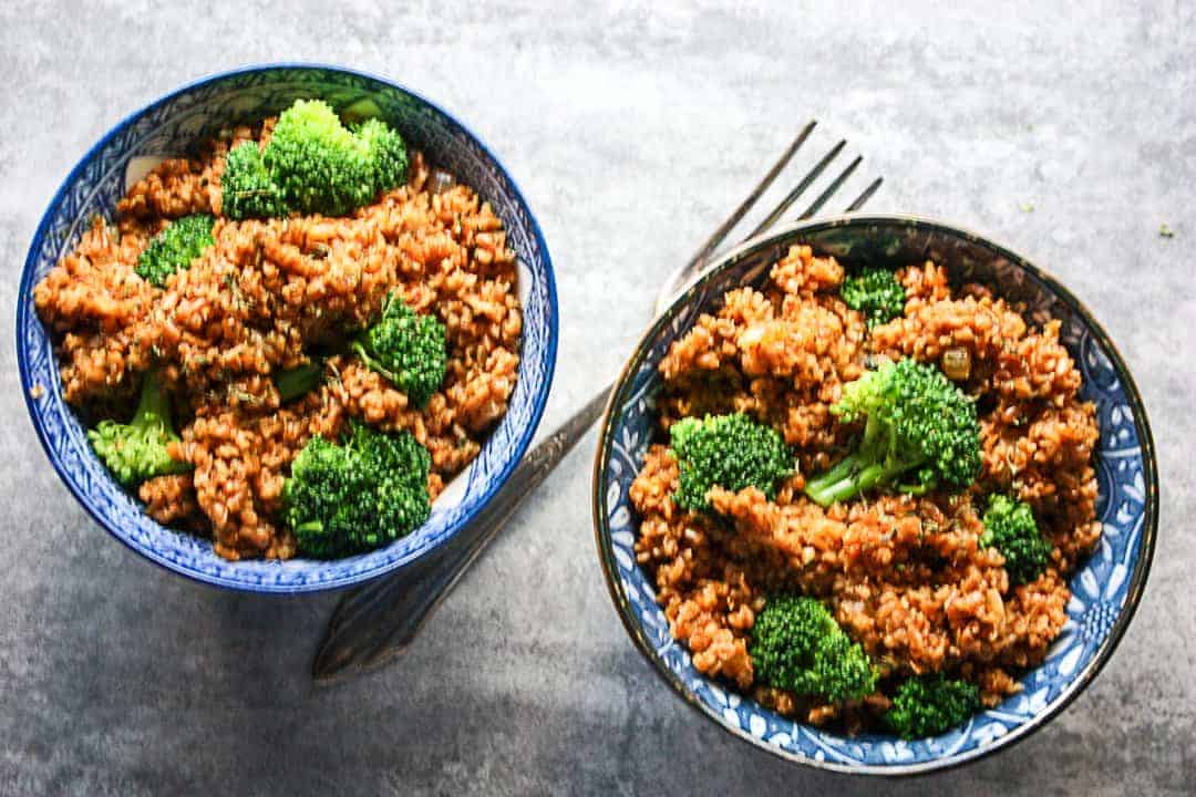 Two bowls of bulgur pilaf with a fork