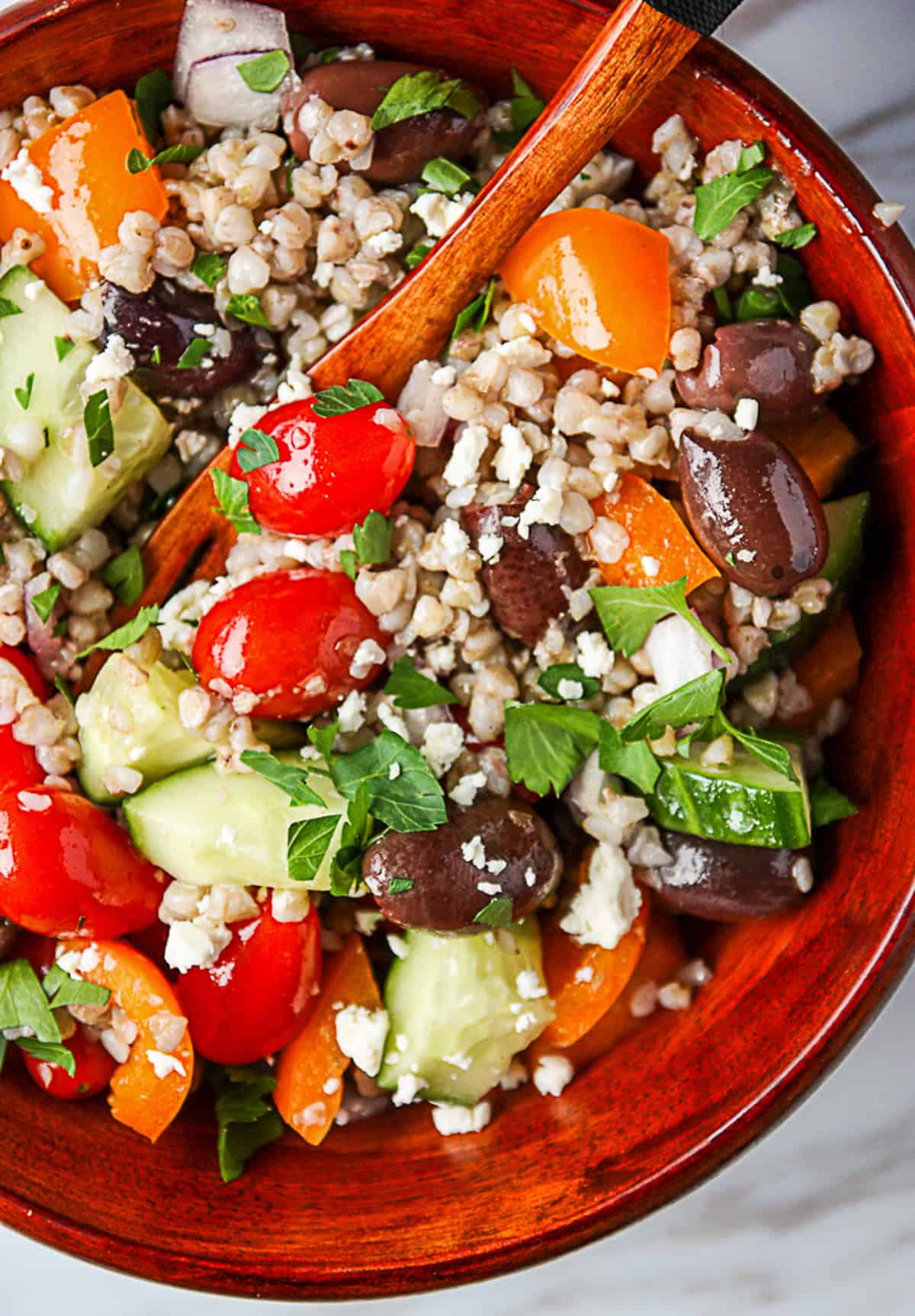 A fork inserted into a bowl of Mediterranean buckwheat salad.