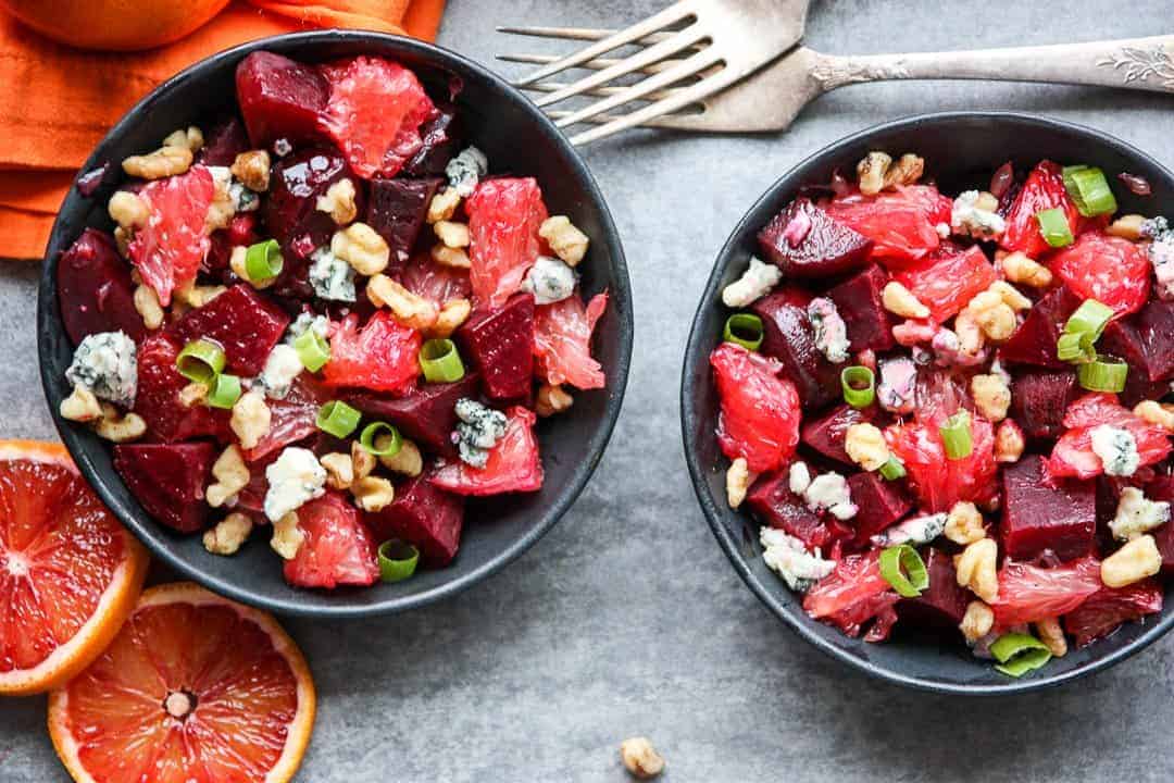 Salad with nuts and blue cheese crumbles in black bowls