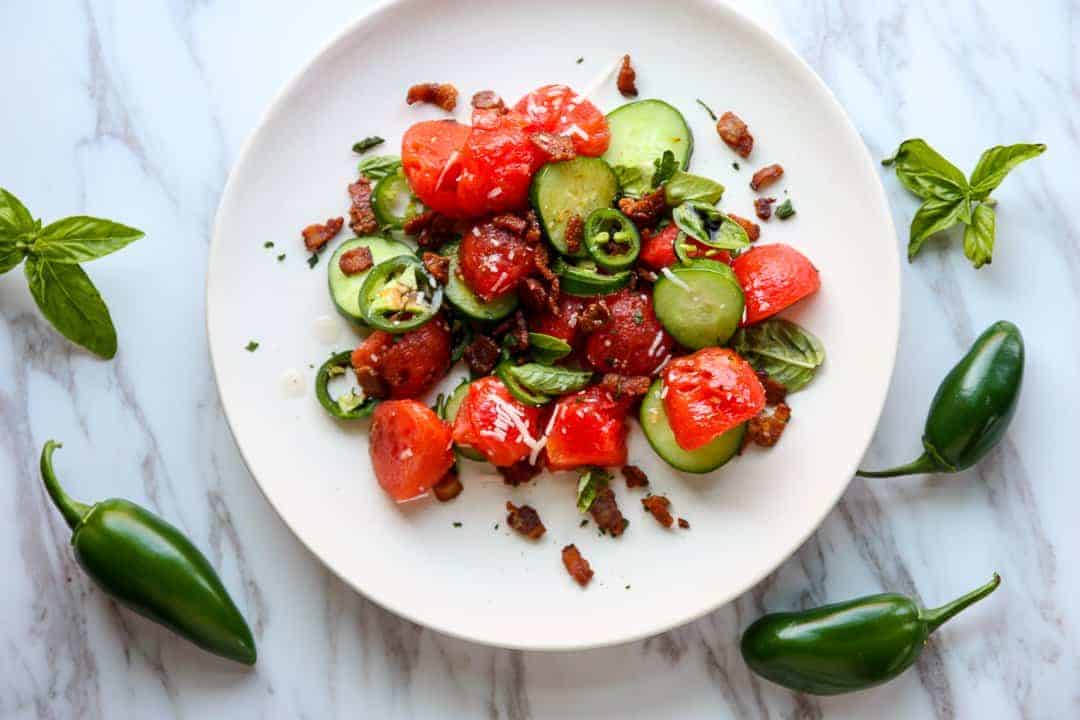 A plate of food on a table, with Melon and Salad