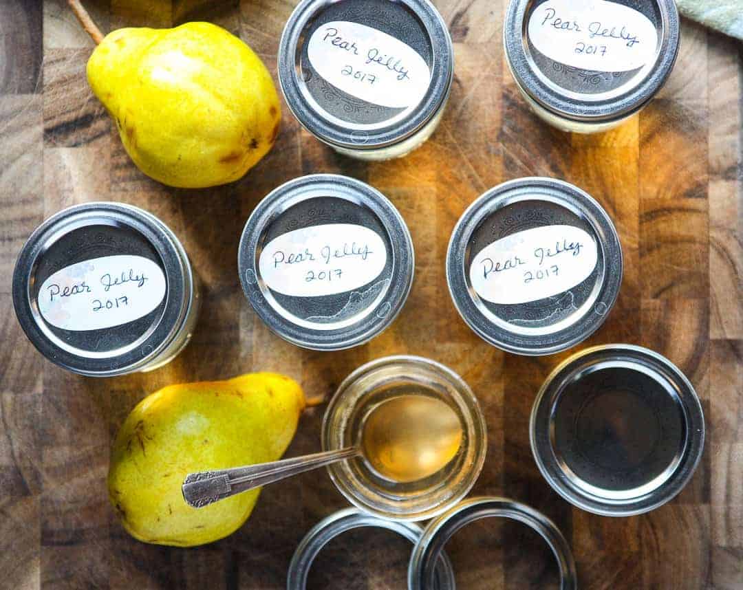 Pears with jars of jelly on a wooden table