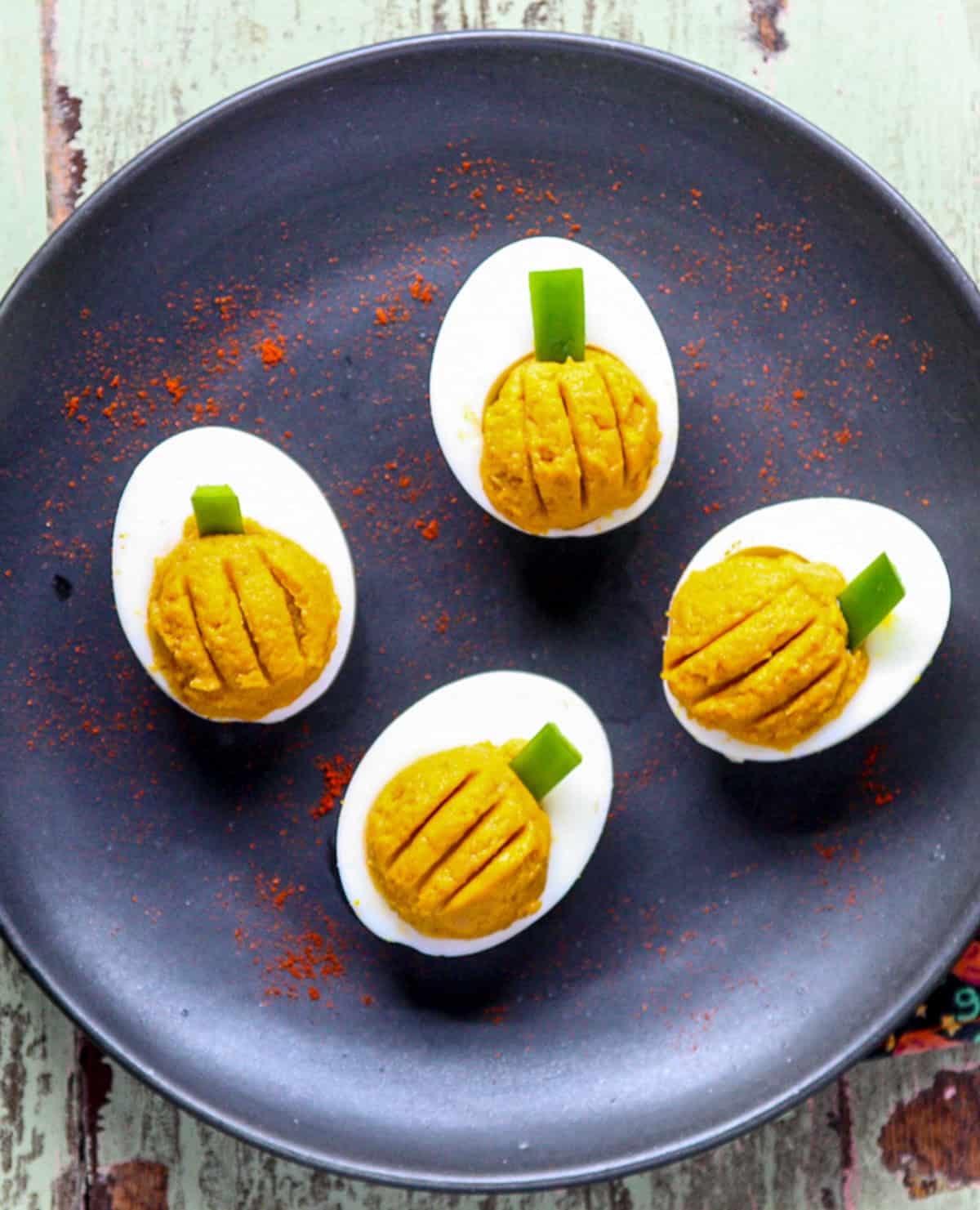 Four Halloween deviled eggs that look like pumpkins.
