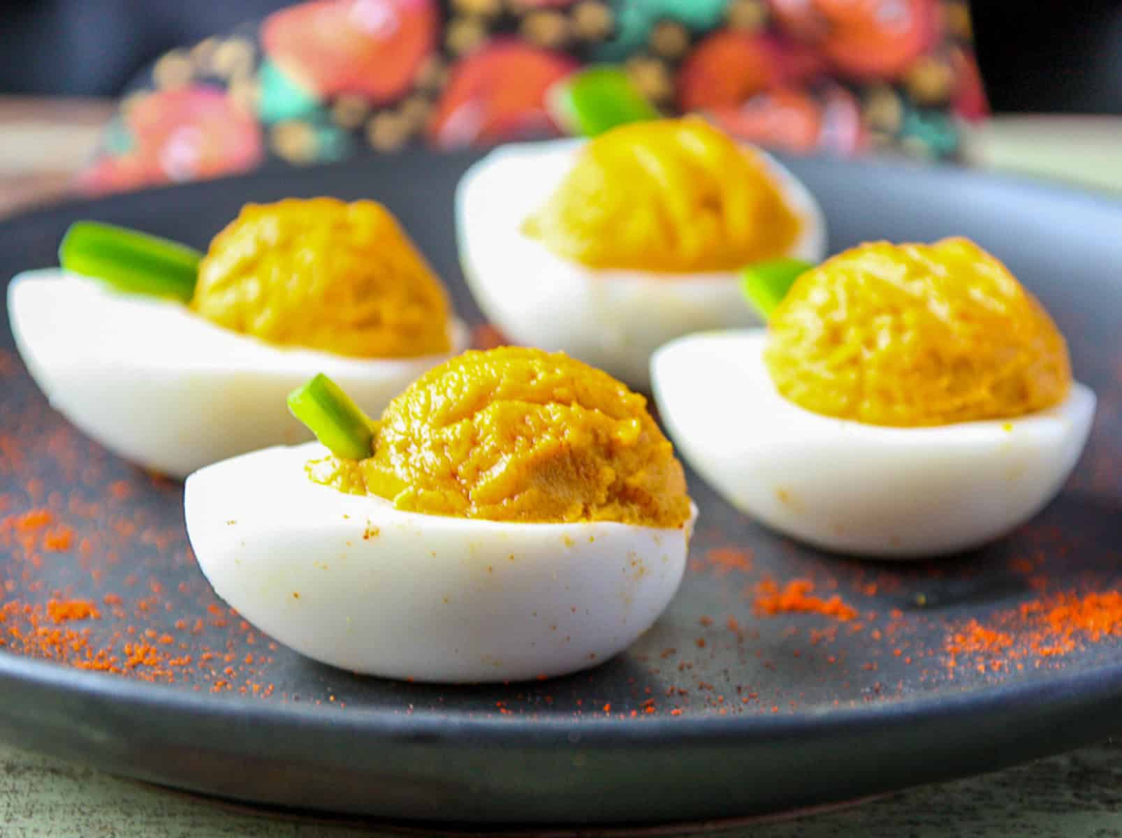 Pumpkin deviled eggs on a plate.