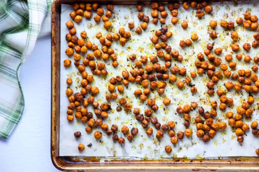 Lemon & spice roasted chickpeas on a parchment lined baking sheet