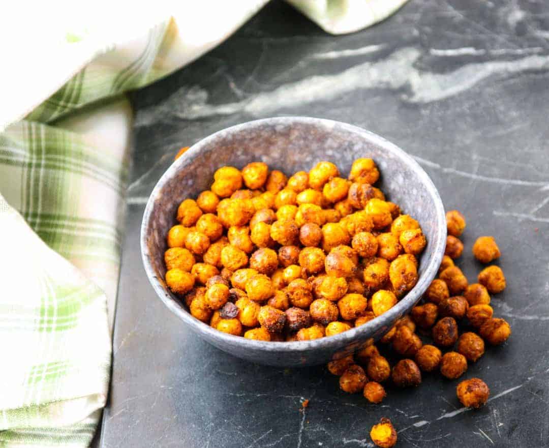 A bowl of roasted chickpeas on a countertop