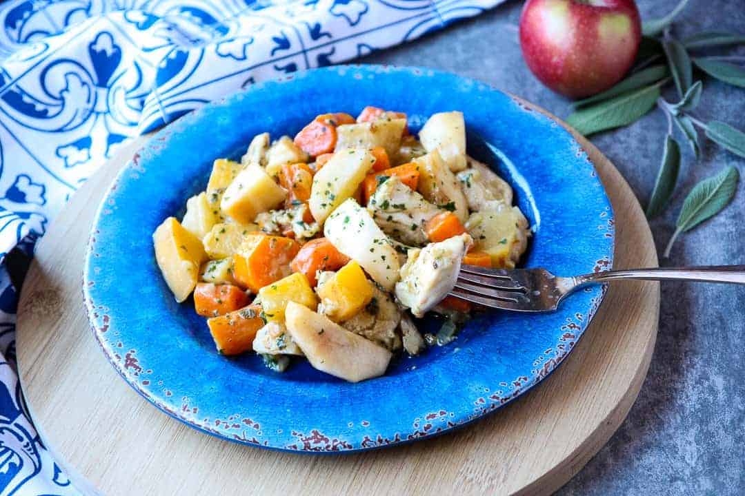 A bowl of food on a blue plate, on a wooden cutting board