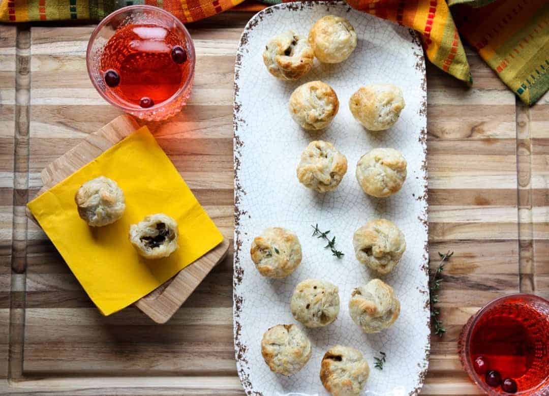 Puff pastry appetizers on a platter on top of a wooden table