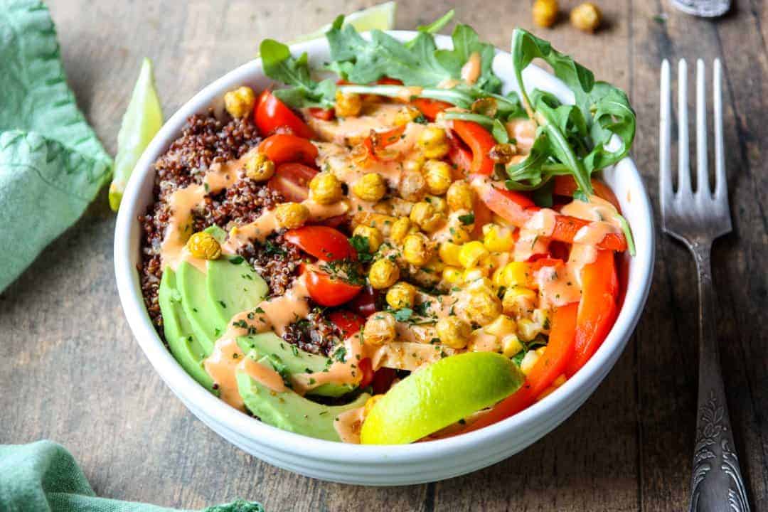 Burrito ingredients in white bowl with fork on wooden table