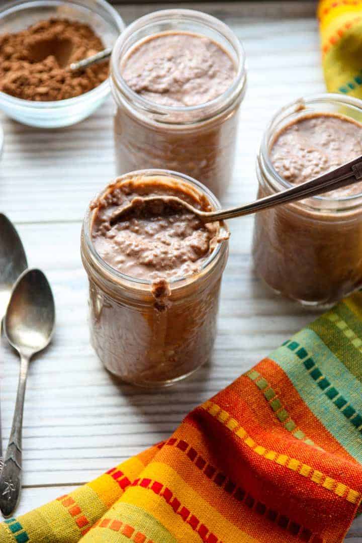 A jar of chocolate pudding with a spoon