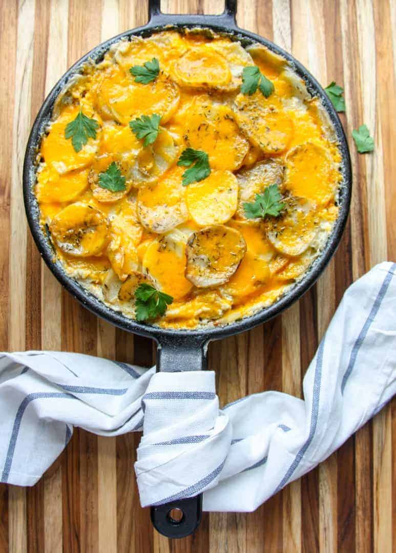 Cast iron skillet pan of baked potatoes au gratin