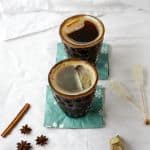 Two drinks in glasses on cocktail napkins