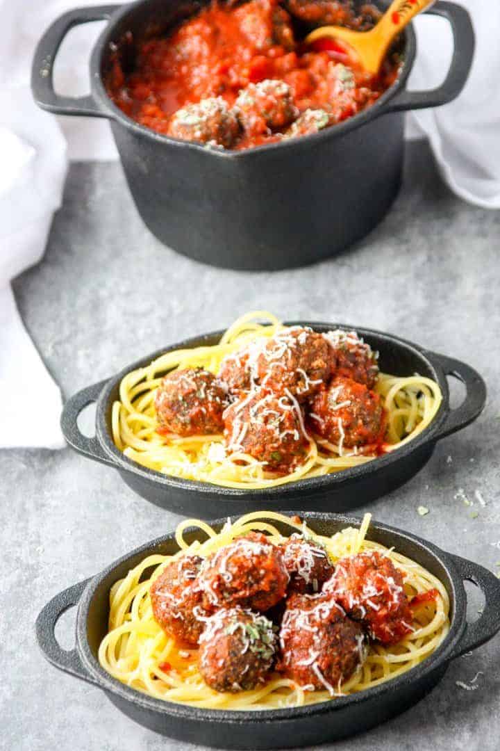 Top shot of two small black skillets with spaghetti and meatballs