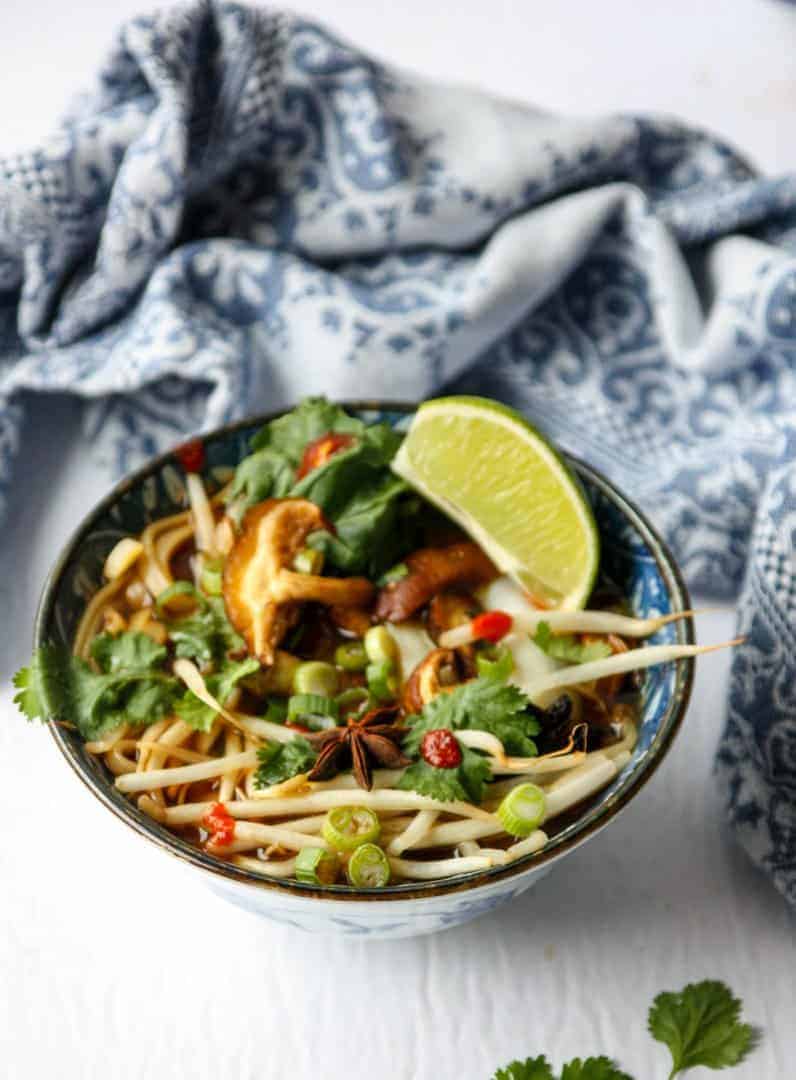 top shot of vegan pho in bowl with lemon wedge