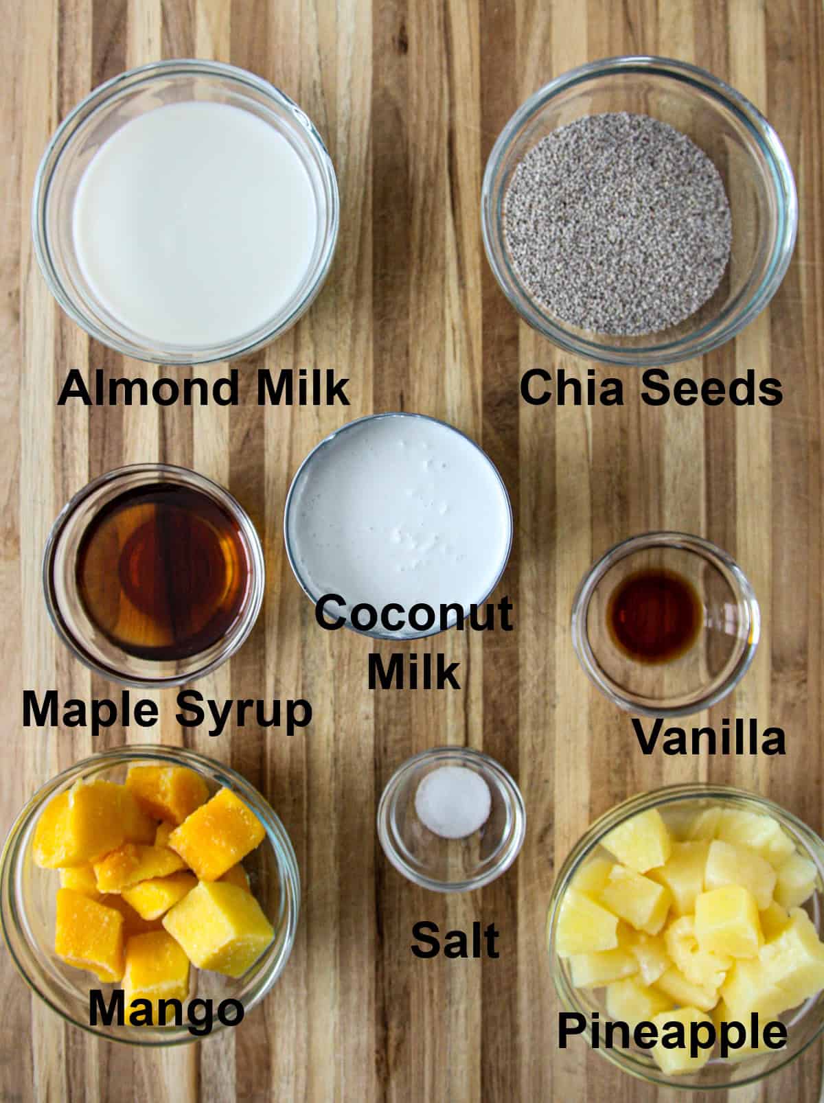 Place all the ingredients for the coconut milk chia pudding in a glass bowl on a wooden board.