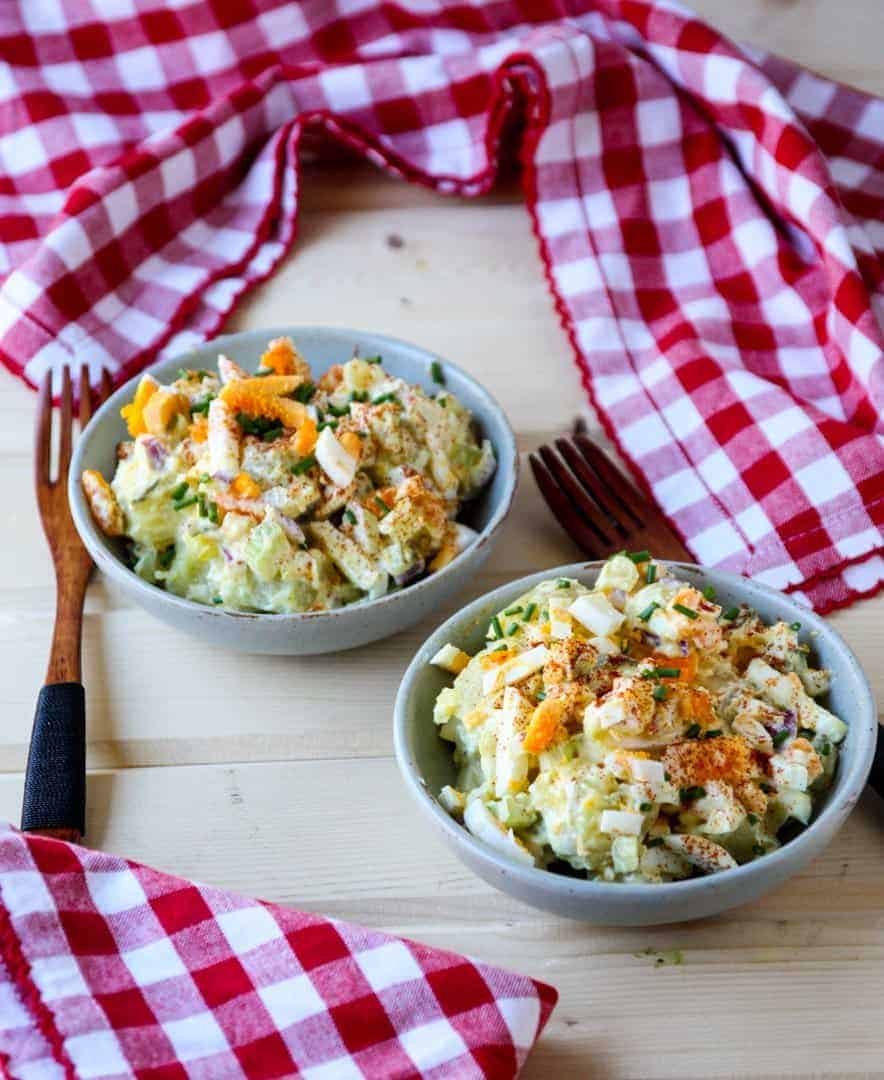 Two bowls of potato salad with red and white checkered napkins