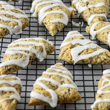 Earl grey scones with lemon icing drizzle on a wire rack.