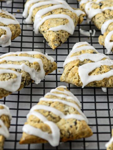 Earl grey scones with lemon icing drizzle on a wire rack.