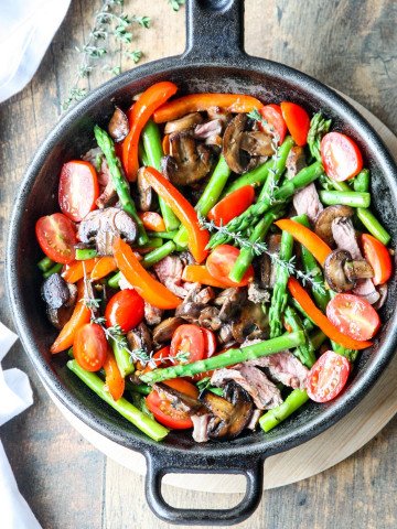 Steak & Asparagus Stir Fry with Red Pepper and Mushrooms in a cast iron pan
