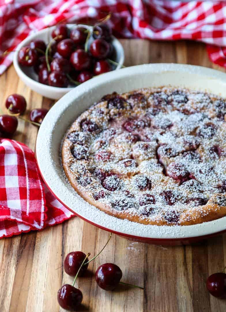 cherry dessert in baking dish sprinkled with powdered sugar