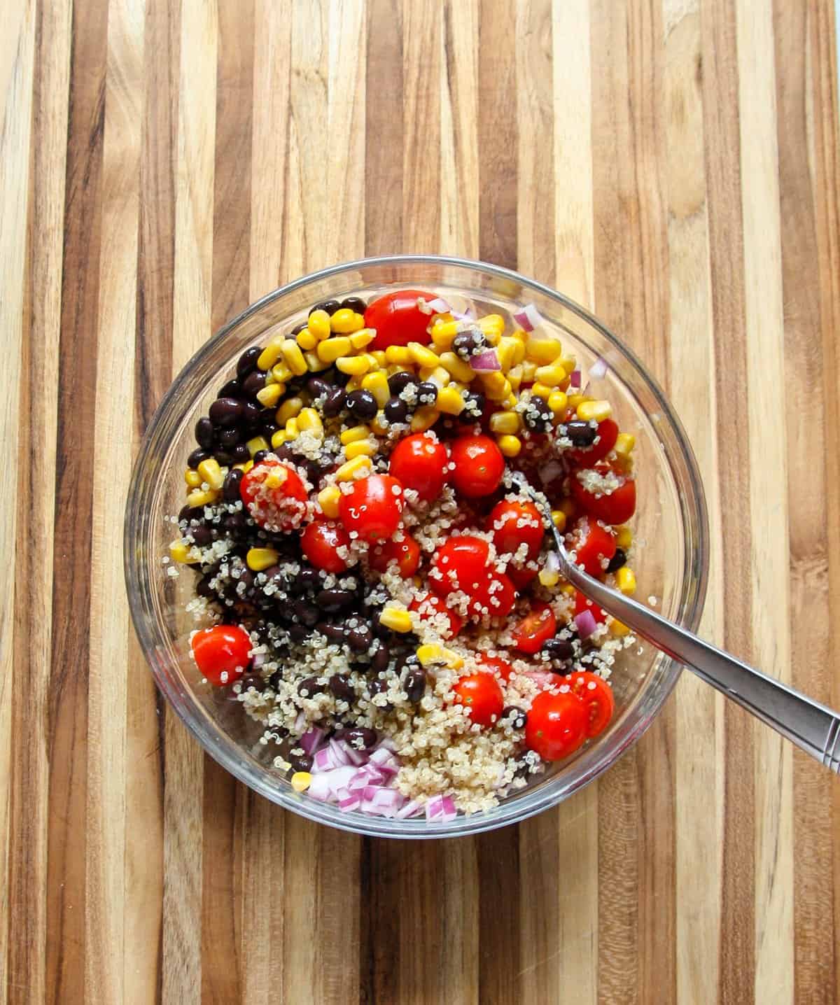 Tossing salad ingredients together in a large bowl.