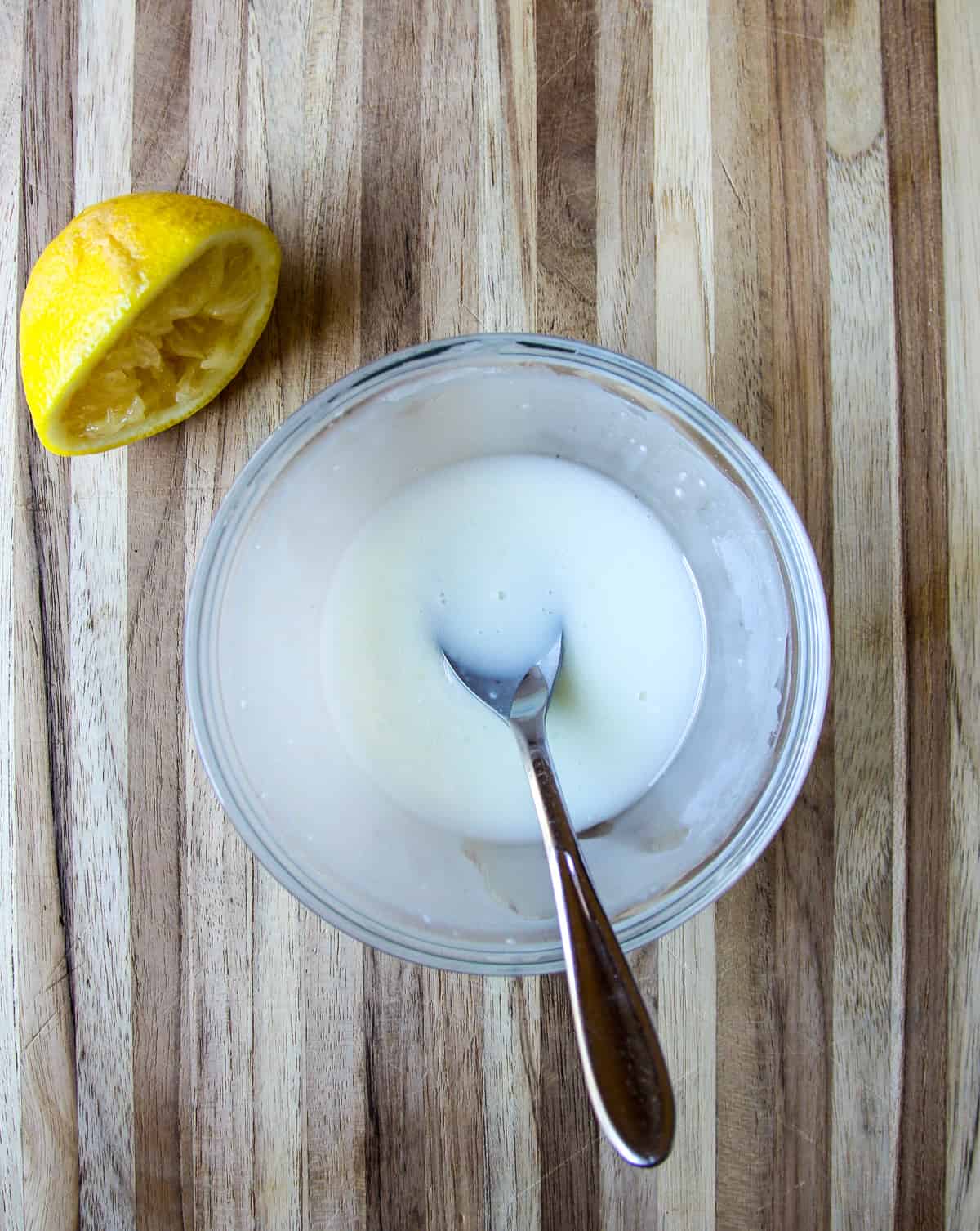 Lemon glaze for gluten-free blueberry scones in a glass bowl.