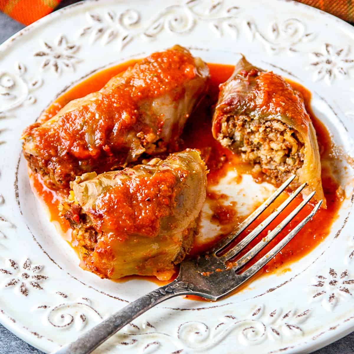 Stuffed Cabbage Rolls on a white plate with a fork.