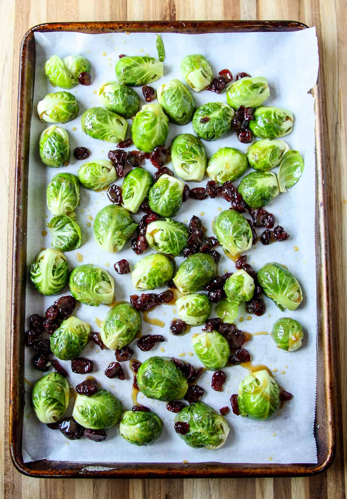 The sugar and mustard coated sprouts spread on a baking sheet.