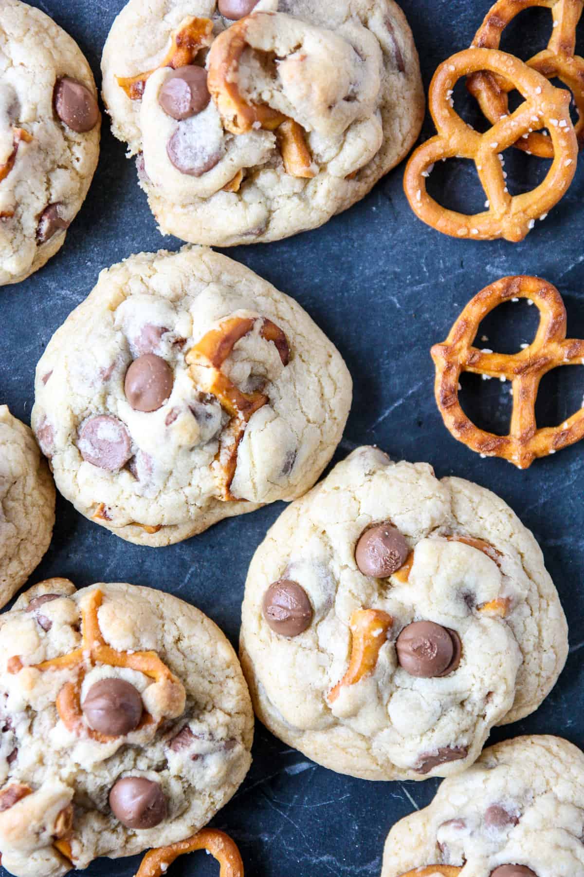 Chocolate chip pretzel cookies on a dark counter top.