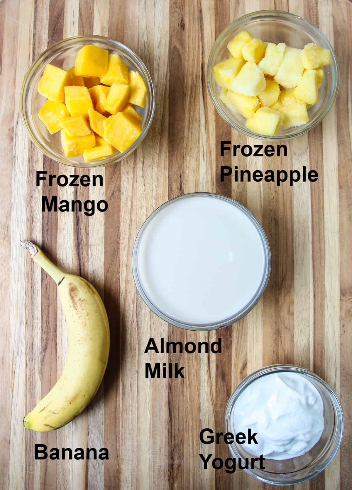 All of the smoothie ingredients on a wooden board.