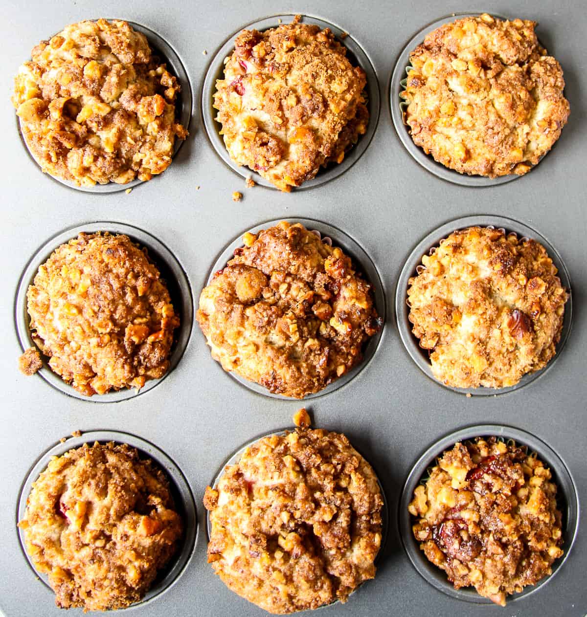 The baked strawberry rhubarb muffins in a muffin tin.