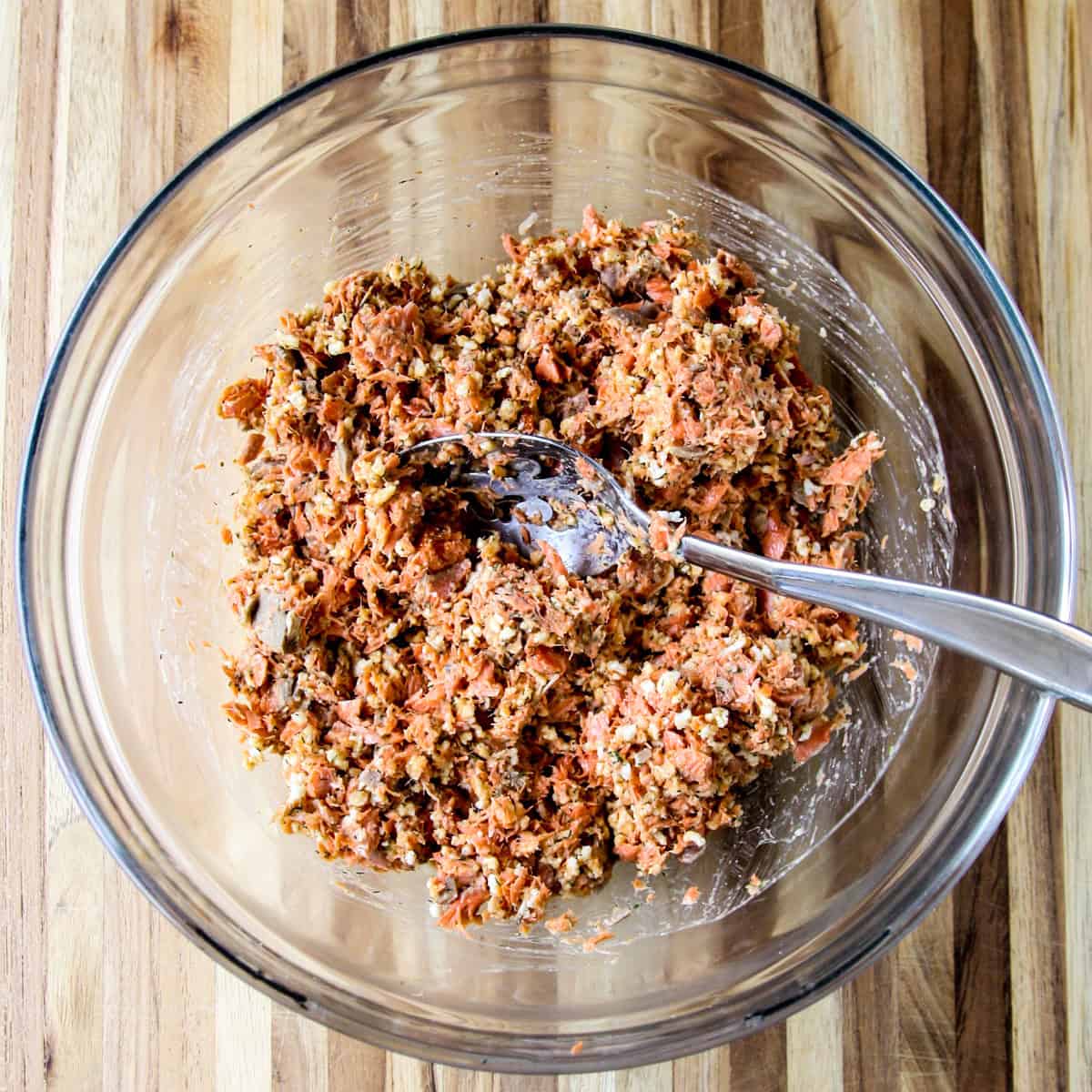 The ingredients being combined in a glass bowl with a spoon.