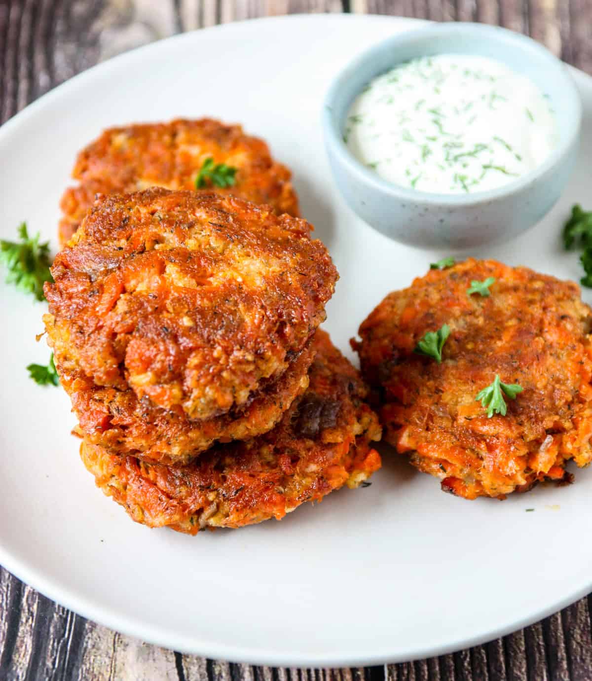 A stack of three salmon patties on a white plate.