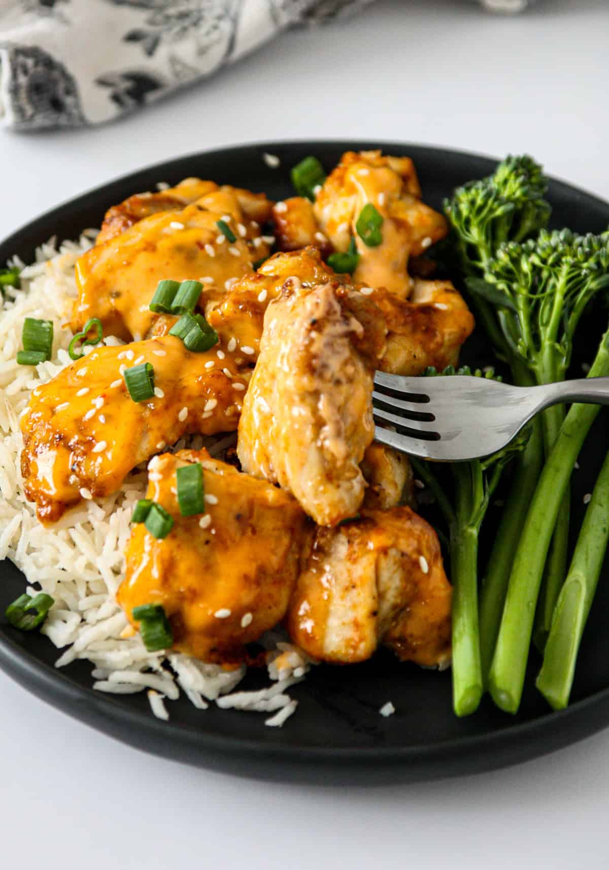 A fork with bang bang chicken on a plate.