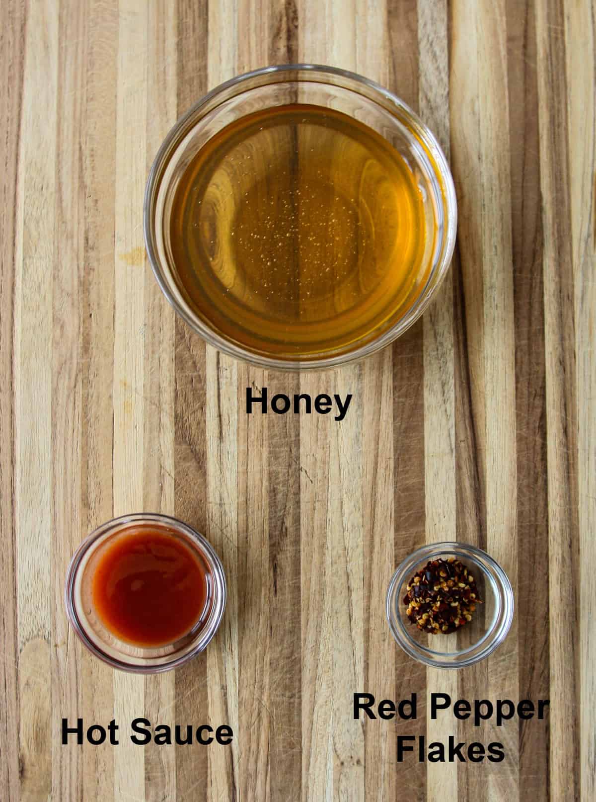 Recipe ingredients in glass bowls on a wooden board.
