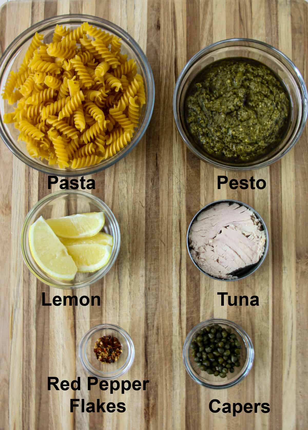 The ingredients for making this recipe, in glass bowls, on a wooden board.